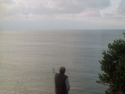 Human silhouette focusing on a distant light point